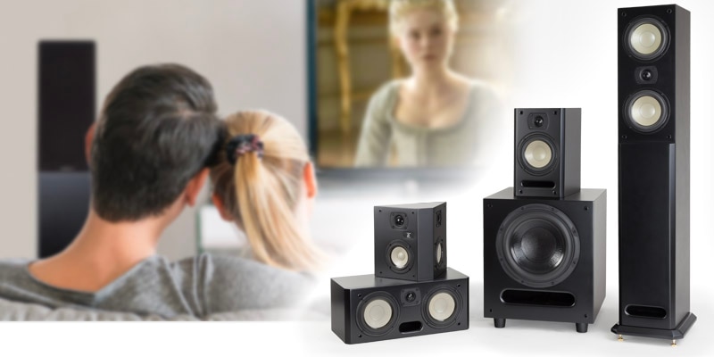Man and woman watching tv. A family of Level Two Cabinet Speakers for home theater or high quality audio.
